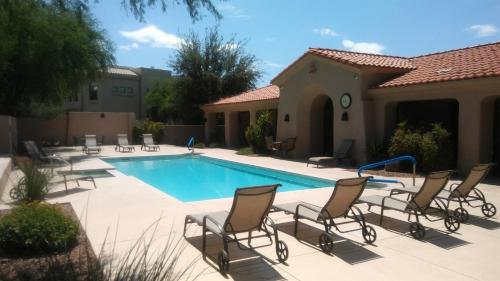une piscine avec des chaises longues et une piscine dans l'établissement Casitas at Sabino Springs, à Tucson