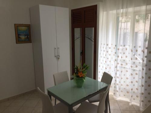 una sala da pranzo con tavolo e sedie verdi di Apartment La Maison a Messina