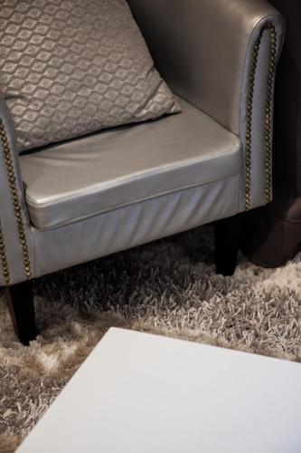 a gray chair and a rug in a living room at Villa Des Ursulines in Bayeux