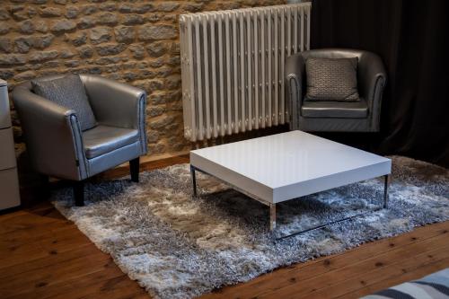 two chairs and a coffee table in a living room at Villa Des Ursulines in Bayeux