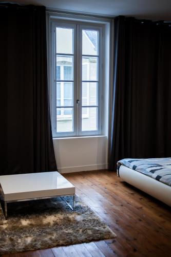 a bedroom with a bed and a window at Villa Des Ursulines in Bayeux