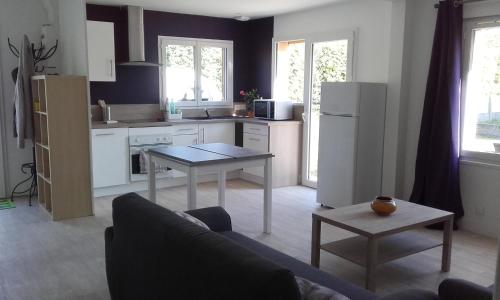 eine Küche mit einem Sofa und einem Tisch in einem Zimmer in der Unterkunft Maison familiale avec jardin au coeur du d day in Port-en-Bessin-Huppain