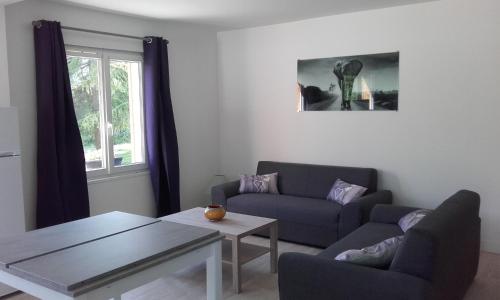 a living room with a couch and a table at Maison familiale avec jardin au coeur du d day in Port-en-Bessin-Huppain