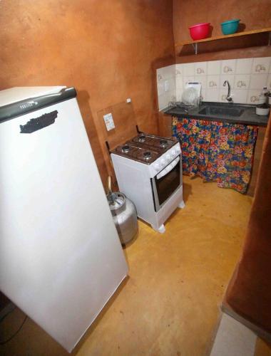a kitchen with a white refrigerator and a stove at Recanto do Baru in Pirenópolis