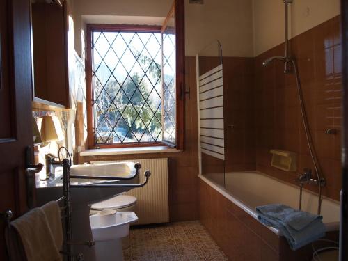 a bathroom with a sink and a tub and a window at Villa Wanda in Cavalese