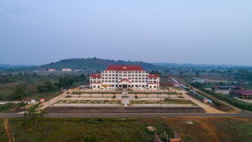 a large white building with a red roof at Paksong Danngarm Hotel in Paksong