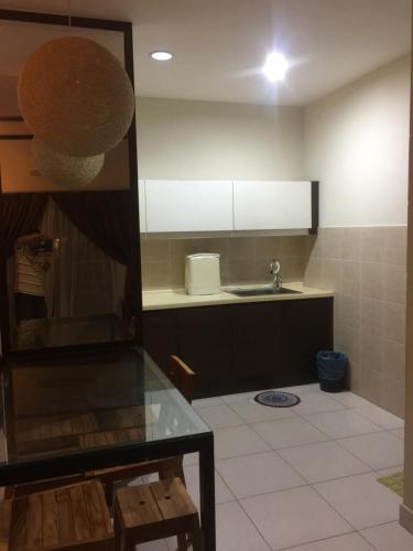 Bestari Homestay @ Gold Coast Morib في Kampong Tanjong Pechah: مطبخ مع حوض و كونتر توب