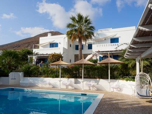 a hotel with a swimming pool with chairs and umbrellas at Villa Ippocampi - Adults Only in Hersonissos