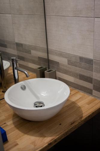 a white sink on a wooden counter in a bathroom at Villa Des Ursulines in Bayeux
