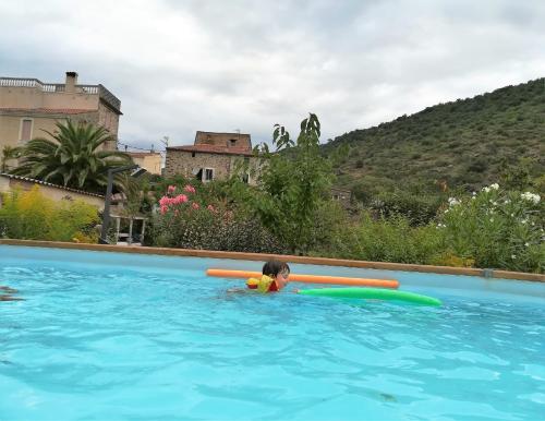 un niño en una piscina con una paleta en Appartement Ria, en Ria