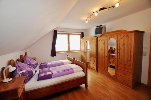 ドナースバッハヴァルトにあるHaus Schindelbacherのベッドルーム(紫色の枕が付くベッド付)