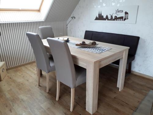 クサンテンにあるFerienwohnung Drömmeljanの木製テーブル(椅子4脚付)