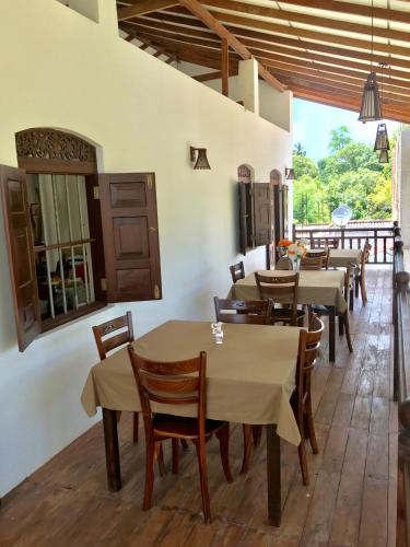 a restaurant with tables and chairs in a room at Hotel La Felicita in Mirissa