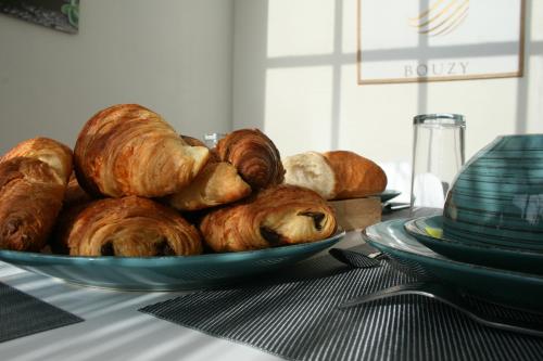 a plate of croissants and bread on a table at L'Iliade - Chambres d'hôtes - B&B à Bouzy in Bouzy
