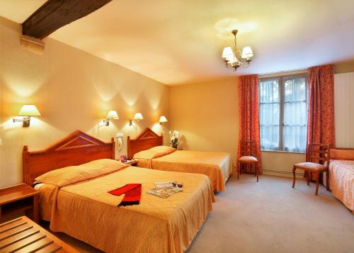a hotel room with two beds and a window at Hostellerie des Trois Pigeons, Paray-le-Monial in Paray-le-Monial