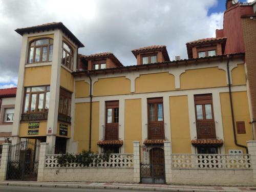 San Andrés del RabanedoにあるBoleta A 5 minutos de León, casa con jardínの窓と柵の黄色い建物