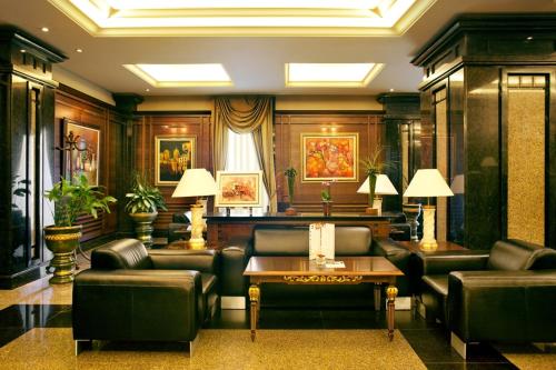 a living room with leather furniture and a table at Grand Hotel Sofia in Sofia