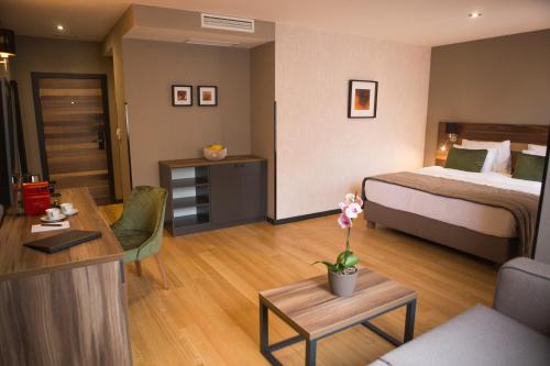 ein Hotelzimmer mit einem Bett und einem Wohnzimmer in der Unterkunft A Hoteli - Hotel Slatina in Vrnjačka Banja