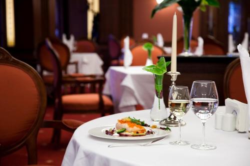 a table with a plate of food and wine glasses at Grand Hotel Sofia in Sofia