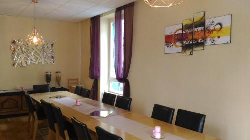 uma sala de jantar com mesa e cadeiras em La Tour Pom'Pin em La Bourboule