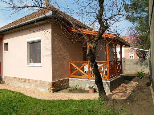 a small white house with a wooden gate at Liliom Apartman in Gyula