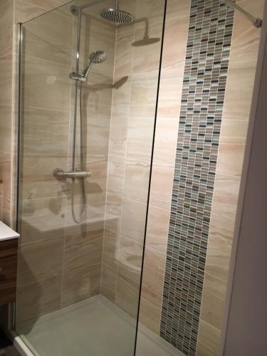 a shower with a glass door in a bathroom at Christiesholidayhomes in Aviemore