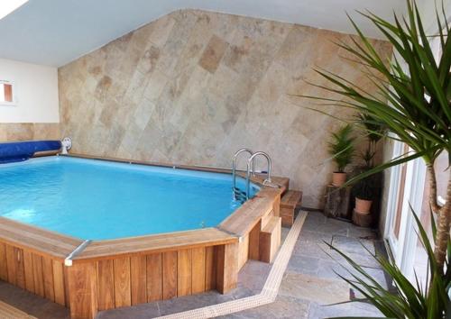 une grande piscine avec une baignoire en bois dans l'établissement La Petite Maison Sous les Pins, à Aix-en-Provence