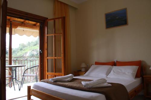 a bedroom with a bed and a balcony at Katerina Rooms in Syvota