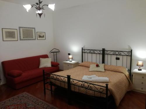 um quarto com uma cama e um sofá vermelho em Ai Tre Portoni em Trento