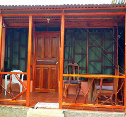 a small house with a wooden door and a table at Jacobin Hostel & Cabins in Drake