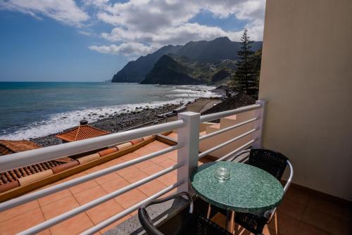 a balcony with a table and a view of the beach at Hotel Costa Linda in Porto da Cruz
