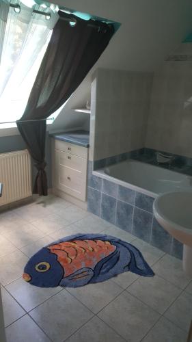 La salle de bains est pourvue d'une baignoire et d'un tapis. dans l'établissement Maison Spacieuse et lumineuse avec piscine privée et chauffée, à Pordic