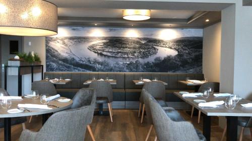 a restaurant with tables and chairs and a painting on the wall at Landgasthof Eiserner Ritter in Boppard