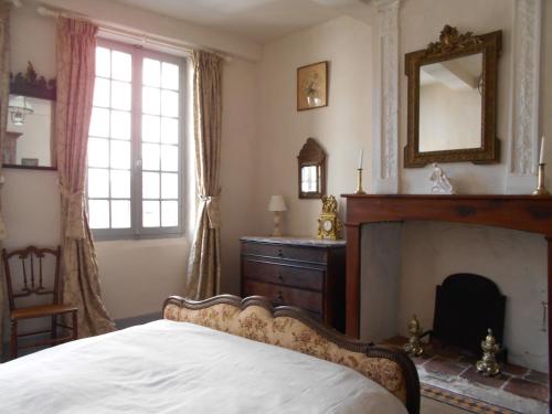 サン・タントナンにある7 Rue Droiteのベッドルーム(暖炉、ベッド、鏡付)