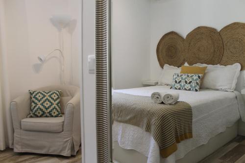 トレドにあるEl Rincón de Puerta Nuevaのベッドルーム(ベッド1台、椅子、鏡付)
