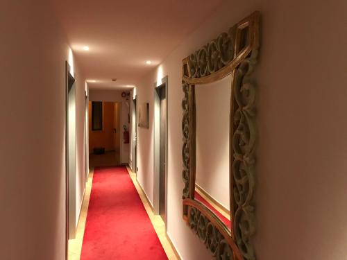 a hallway with two mirrors and a red carpet at Hotel Villa Rosa in Sirmione