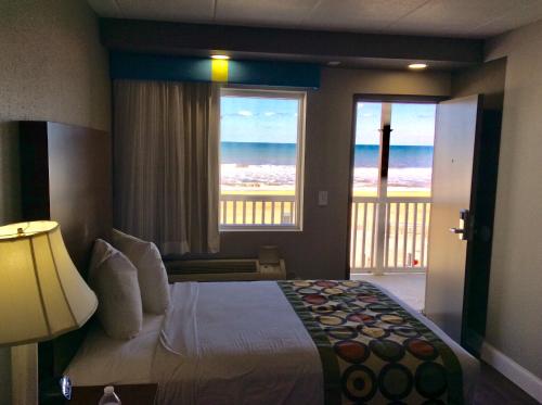 a bedroom with a bed with a view of the ocean at Ocean's 24 in Virginia Beach