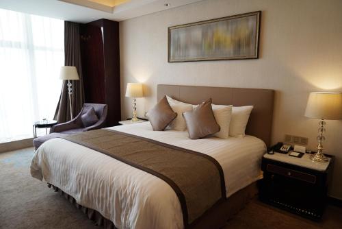 a hotel room with a large bed and a chair at Landhotel Becker in Kamp-Bornhofen