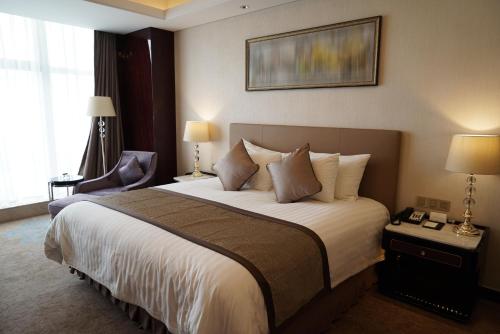 カンプ・ボルンホーフェンにあるLandhotel Beckerの大きなベッドと椅子が備わるホテルルームです。