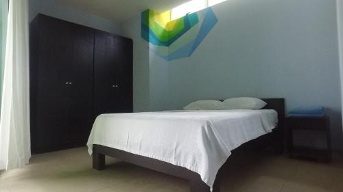 a bedroom with a bed with a rainbow painting on the wall at Room2Board Hostel and Surf School in Jacó