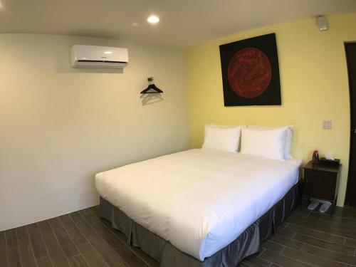 a bedroom with a large white bed in a room at 800 Lan Homestay in Zhushan