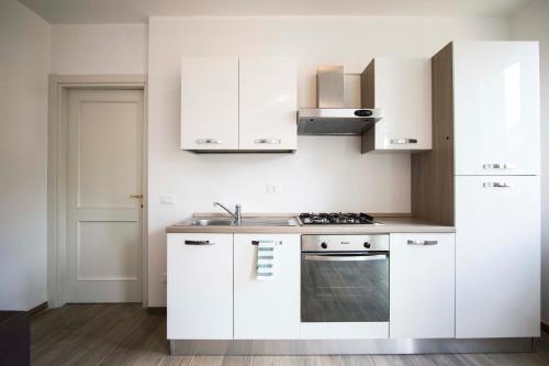 a white kitchen with white cabinets and a sink at Santa Caterina in Levanto