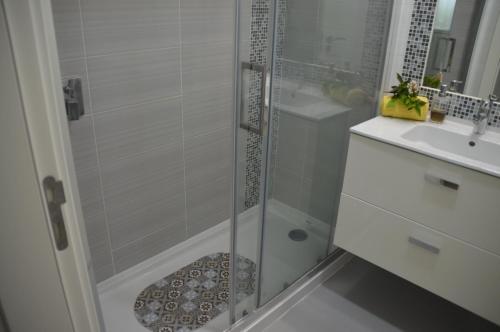 a bathroom with a shower and a sink at Amazing Beach & Pool Apartment with Garden in Sesimbra