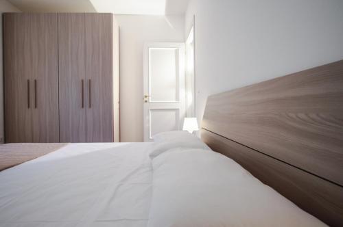 a bedroom with a white bed with a wooden headboard at Santa Caterina in Levanto
