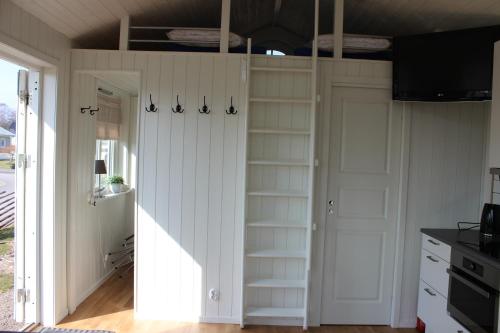 a room with a closet with shelves and a door at Smeakalles in Tvååker