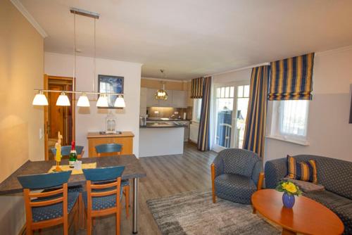 a living room and kitchen with a table and chairs at Apartment 85 im Dünenpark in Binz