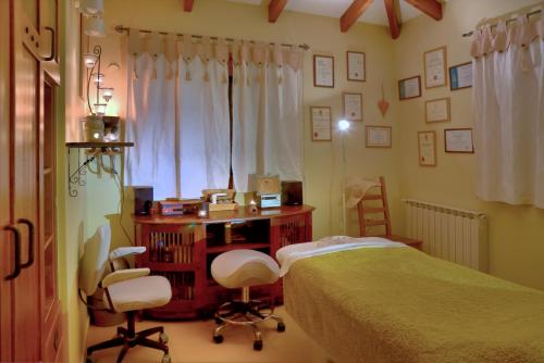Kefar Weradim的住宿－The Rose Trail，卧室配有一张床、一张桌子和椅子