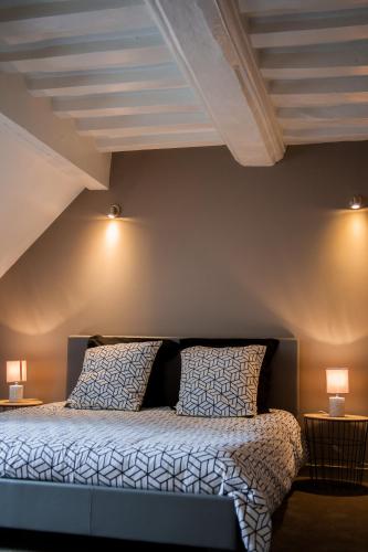 a bedroom with a bed with two pillows and two lamps at Villa Des Ursulines in Bayeux