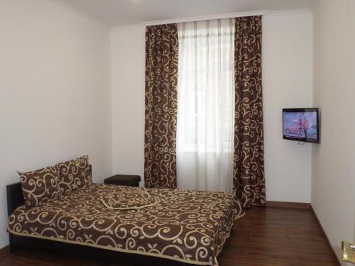 リヴィウにあるApartment on Vienietsianova 13のベッドルーム(ベッド、カーテン、テレビ付)
