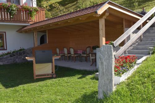 a patio with a table and chairs in a backyard at Trafisolerhof in Vols am Schlern